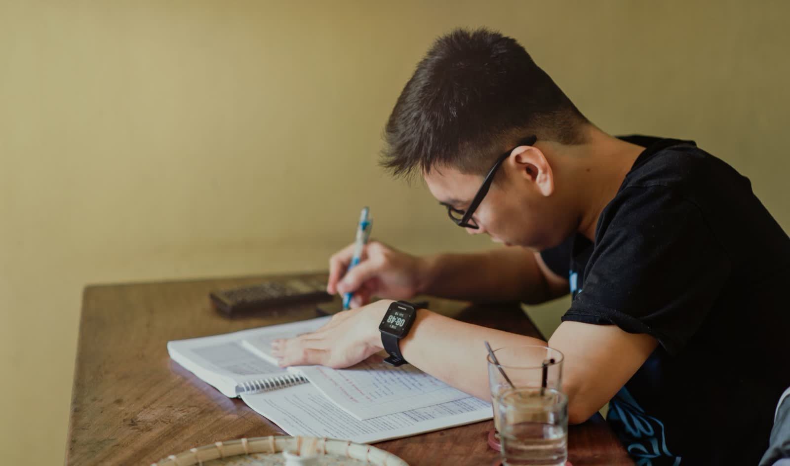 A student writing an essay at a desk